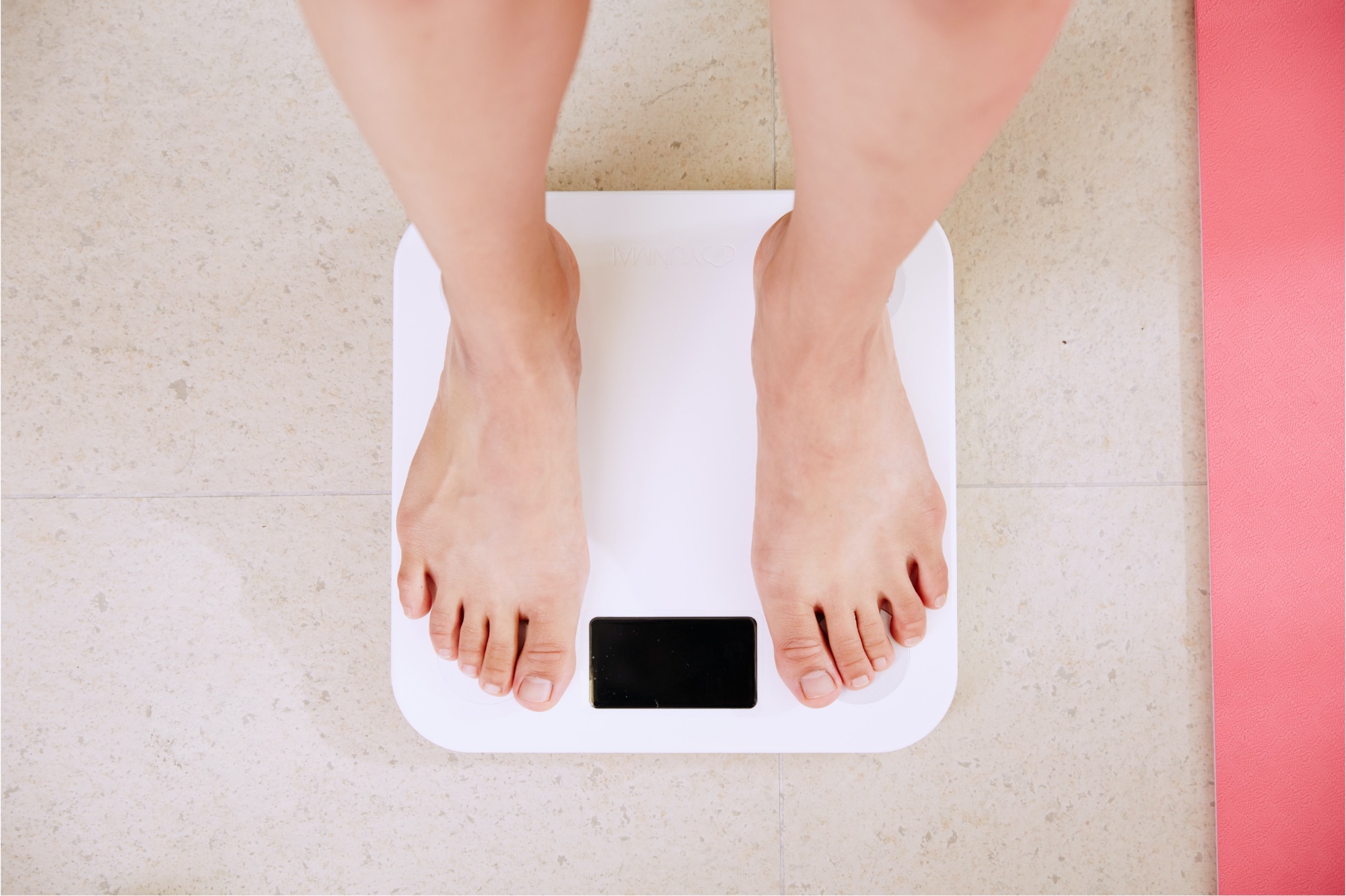 Na zdjęciu nogi osoby stojącej na wadze.