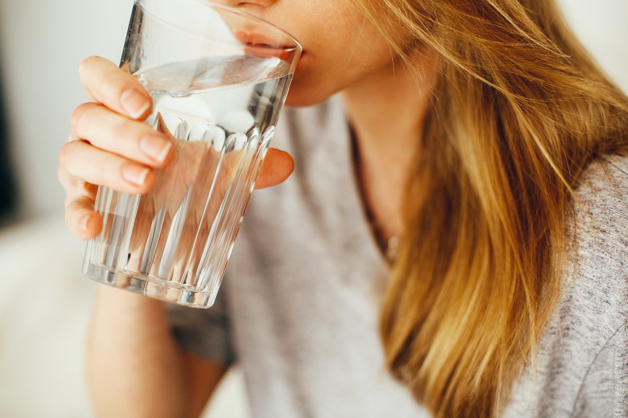 Picie wody - na zdjęciu osoba pijąca wodę